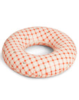 Checkered donut pillow with red and white pattern on a white background